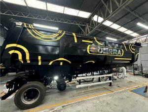 Implemento rodoviário da Guerra dentro do galpão, pintado de preto com grafismos amarelos