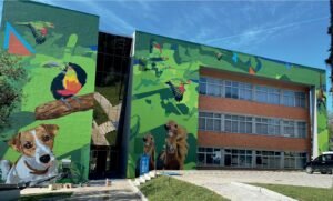 Fachada do hospital veterinário IHVET pintada com um cachorro e um tucano em cores fortes
