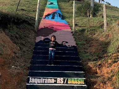A escadaria de Jaquirana vista do alto, com uma pessoa parada no meio dos degraus pintados